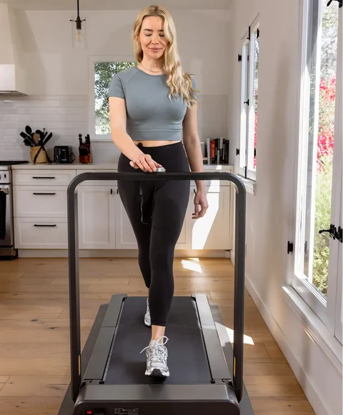 Woman walking on the Movaped X21 foldable treadmill during an indoor workout